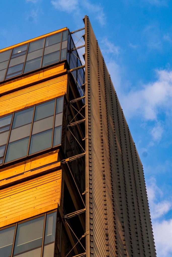 Architectural photograph of a modern office building illuminated by warm evening sunlight against a blue sky.